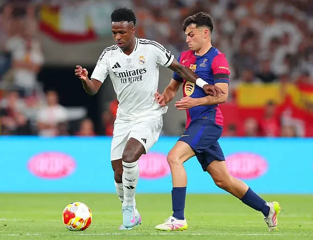 بيدي يحاول اعتراض فينسيوس خلال مباراة برشلونة ضد ريال مدريد الان في كأس ملك إسبانيا