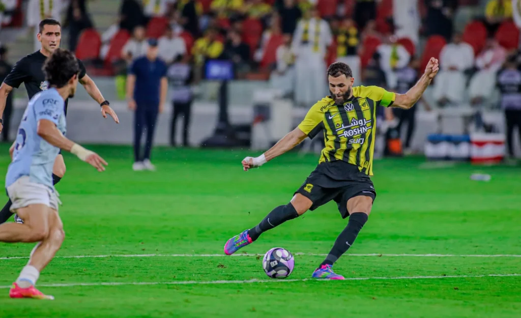 كريم بنزيما لحظة تسديد الكرة في مباراة الاتحاد ضد الفيحاء بالجولة 31 من دوري روشن السعودي